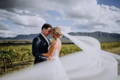 Bride and groom sharing an intimate moment just outside Enzo Hunter Valley with vineyard views behind them